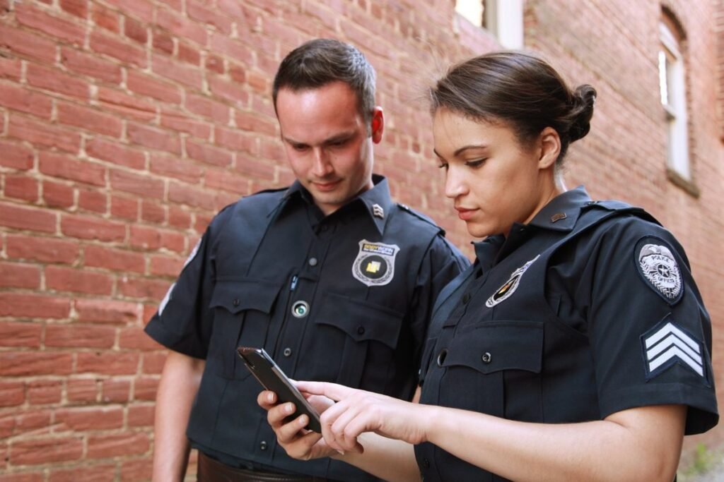 Two security officers reviewing information on a smartphone, representing essential security hacks and tips.