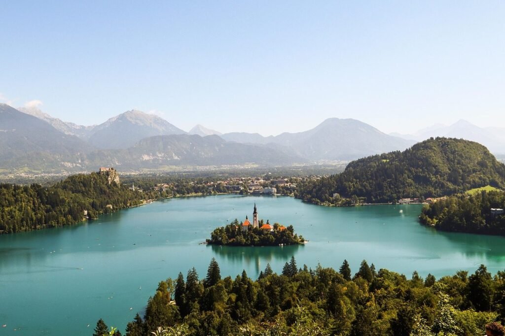 Breathtaking view of Lake Bled, Slovenia, with its iconic island church surrounded by turquoise waters and Alpine mountains.